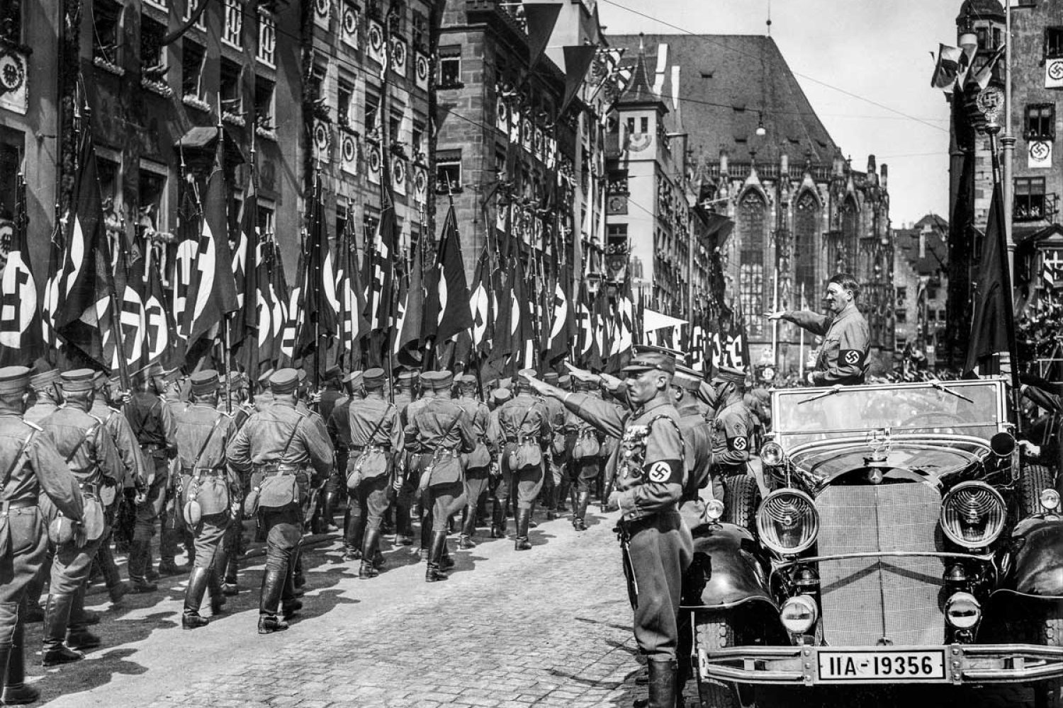 Rallye de Nuremberg sa 1930s avec Adolf Hitler debout dans sa Mercedes-Benz 770 en train de passer en revue les membres de sa (Sturmabteilung) lors d'un défilé lors du rallye de Nuremberg 1935, le Congrès du Parti nazi de 7th s'est tenu à Nuremberg, 10 septembre–16. Hitler est accompagné par le Blutfahne (drapeau de sang) et son porteur SS-Sturmbannführer Jakob Grimminger.